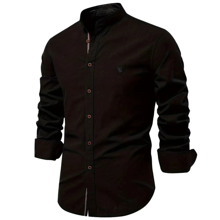 Cette chemise noire à manches longues présente un col Mao élégant et des boutons en bois contrastés. Avec un logo brodé sur la poitrine, elle combine style et confort pour un look chic et décontracté, parfait pour les journées fraîches.