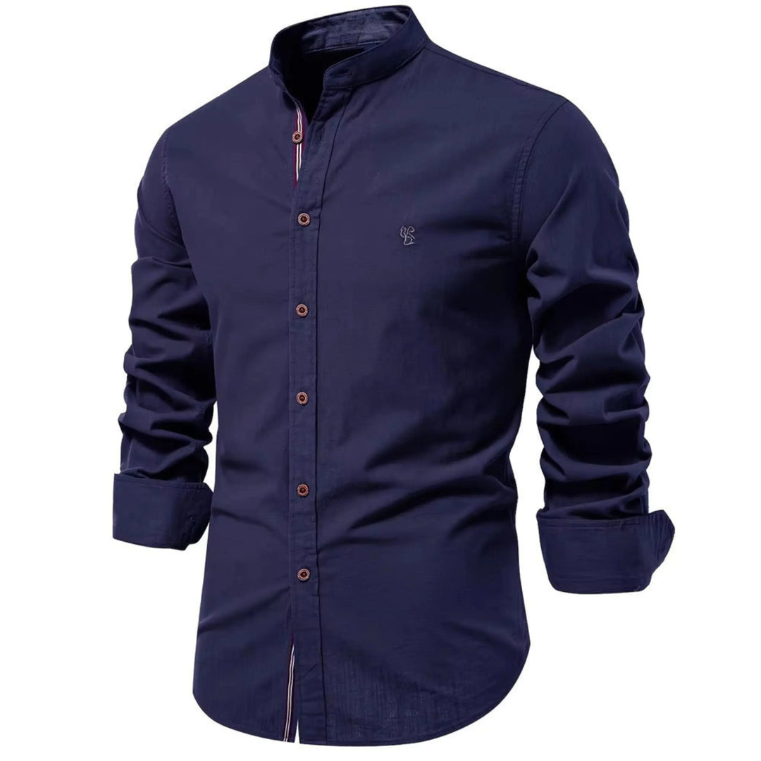 Cette chemise à manches longues de couleur bleu marine présente un col Mao et des boutons en bois contrastés. Elle est décorée d’un petit logo brodé sur la poitrine, combinant élégance et confort pour un look chic et moderne.