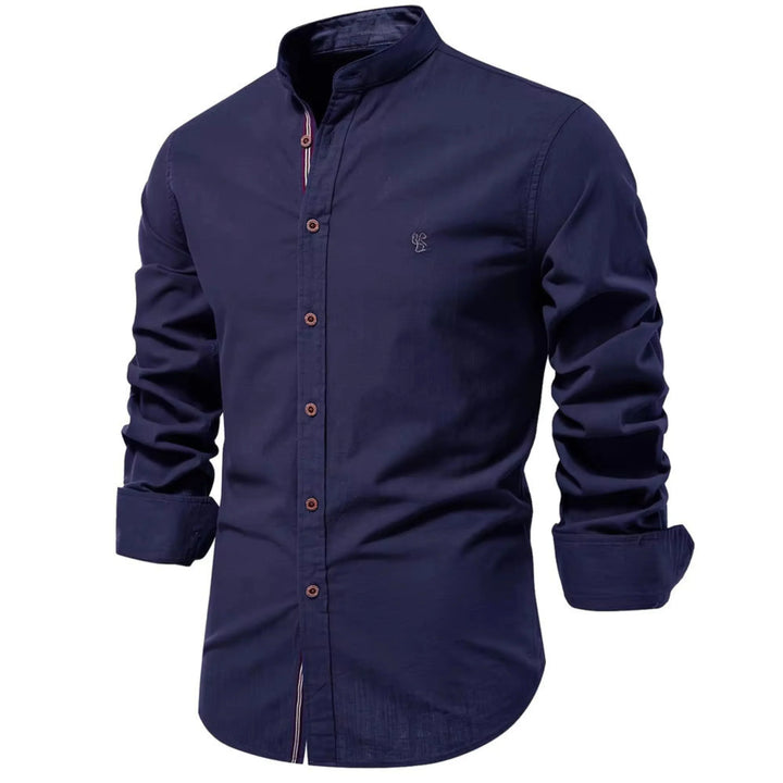 Cette chemise à manches longues de couleur bleu marine présente un col Mao et des boutons en bois contrastés. Elle est décorée d’un petit logo brodé sur la poitrine, combinant élégance et confort pour un look chic et moderne.