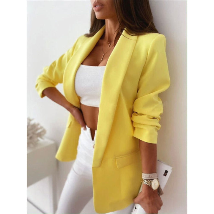 Blazer jaune pour femme, porté sur un top blanc et un pantalon blanc, créant un look lumineux et moderne. Un choix chic et décontracté, parfait pour un style estival et élégant.