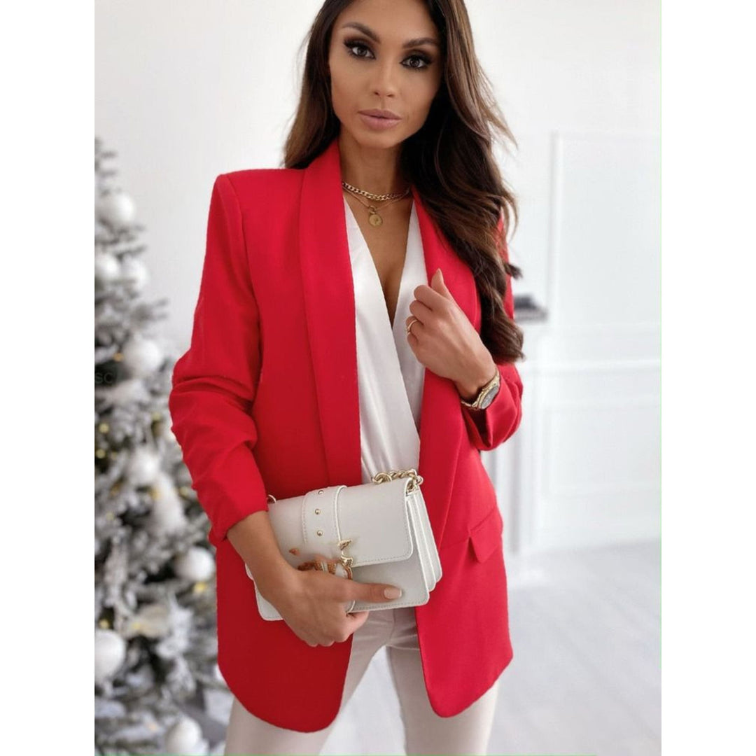 Blazer rouge vif pour femme, porté avec un top blanc et un pantalon beige. Un look élégant et moderne, parfait pour un style sophistiqué et tendance, idéal pour des occasions formelles ou décontractées.