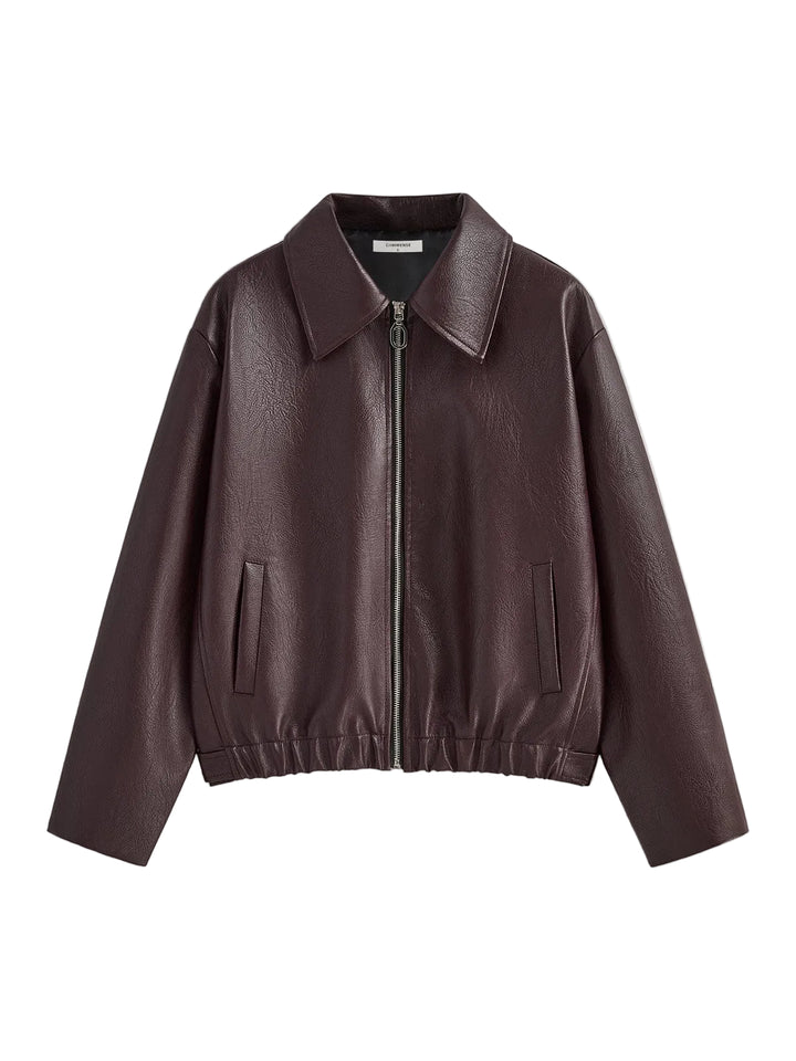 Veste en simili cuir bordeaux avec col large, fermeture zippée et taille élastiquée, offrant une coupe moderne et féminine, idéale pour un look élégant et décontracté.