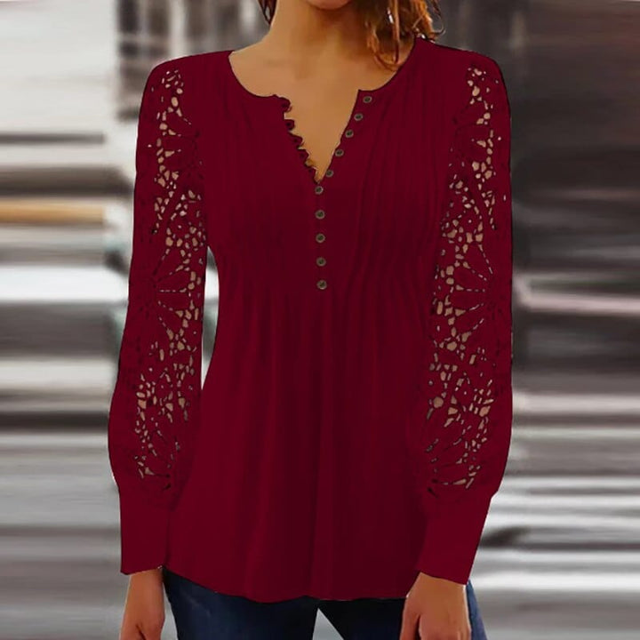 Une blouse tendance et élégante, en bordeaux, avec des manches longues en dentelle délicate. Le décolleté en V avec des boutons ajoute une touche féminine et moderne, idéale pour un look chic et décontracté.