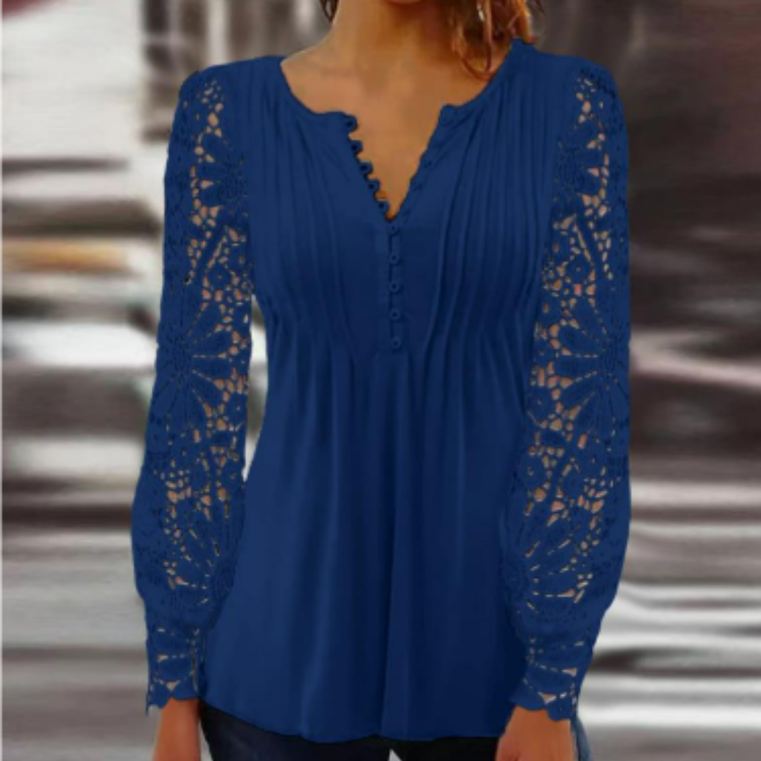 Une blouse élégante en bleu, avec des manches longues en dentelle délicate. Le décolleté en V et les boutons ajoutent une touche féminine et moderne, parfaite pour un look chic et décontracté.