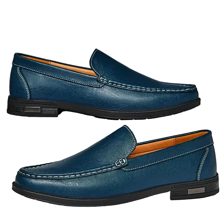 Mocassins classiques homme bleu marine en similicuir, coutures apparentes et semelle noire, présentés de profil style moderne et élégant pour le quotidien.