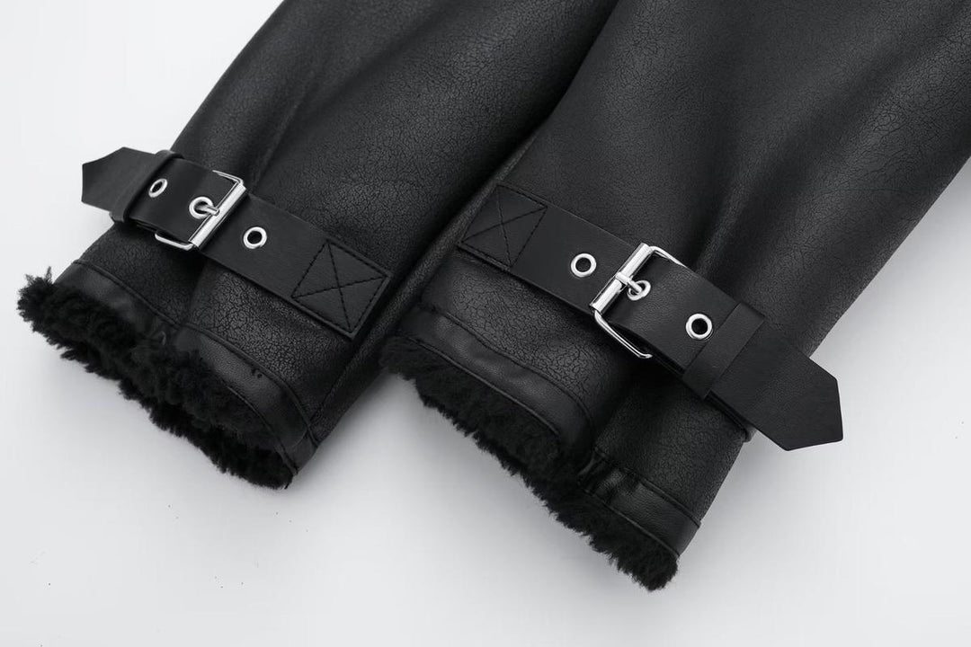 Détail des manches d’une veste courte noire pour femme, présentant des sangles ajustables en métal et une bordure intérieure en fausse fourrure pour un style hivernal chaud et élégant.