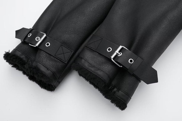 Détail des manches d’une veste courte noire pour femme, présentant des sangles ajustables en métal et une bordure intérieure en fausse fourrure pour un style hivernal chaud et élégant.