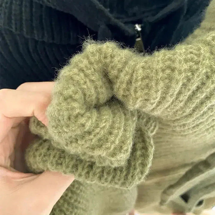 Un gros plan sur la texture douce et épaisse d'un tissu tricoté vert met en valeur la qualité du fil et le fini moelleux du vêtement. L'image souligne la matière chaude et confortable, idéale pour les journées fraîches.