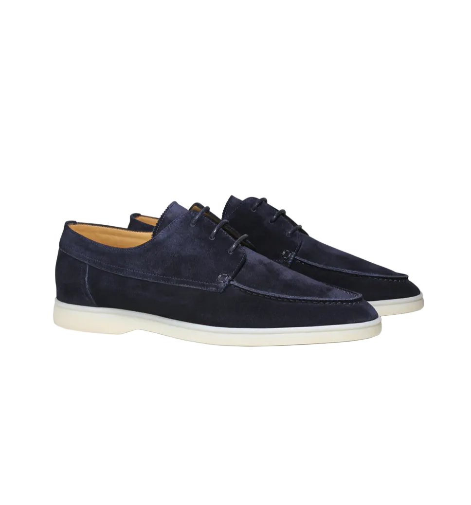 Paire de mocassins derbies en suédine bleu marine avec lacets et semelle claire, vue produit sur fond clair, style élégant et moderne.