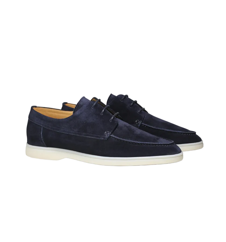 Paire de mocassins derbies en suédine bleu marine avec lacets et semelle claire, vue produit sur fond clair, style élégant et moderne.
