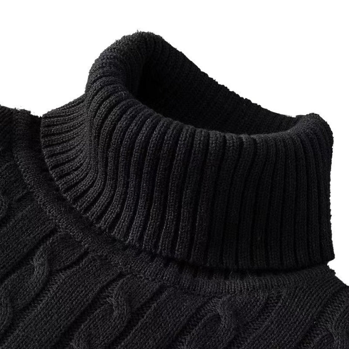 Zoom sur le col roulé d'un pull noir en maille côtelée à motif torsadé.