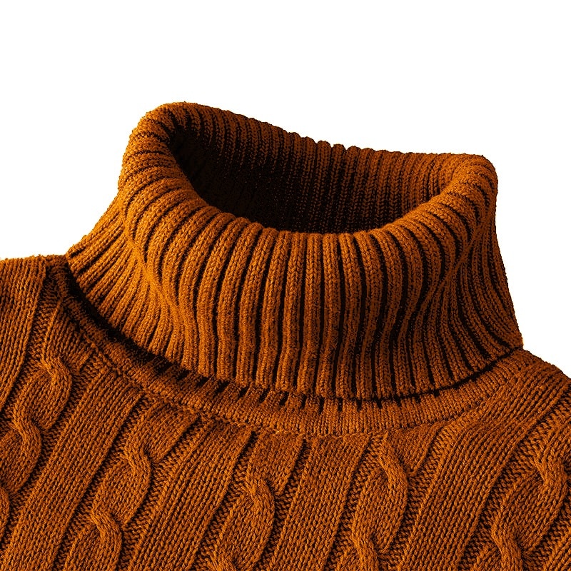 Zoom sur le col roulé d'un pull orange en tricot côtelé avec un motif en torsades.