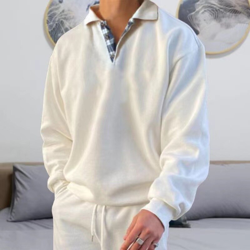 Pull d’été homme Michel moderne, haut blanc à col polo avec détail intérieur à carreaux, manches longues et coupe décontractée, porté avec pantalon clair pour un style casual chic.
