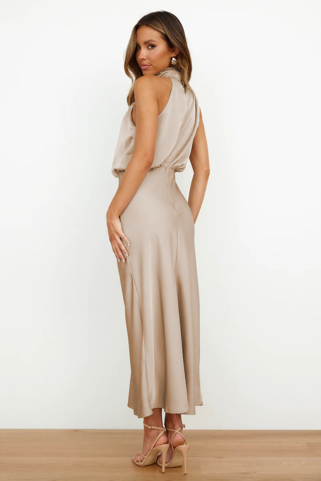 Cette robe en satin beige offre une coupe fluide et élégante. Son dos nu subtil et son design raffiné créent une silhouette chic, idéale pour des événements formels ou des soirées spéciales.