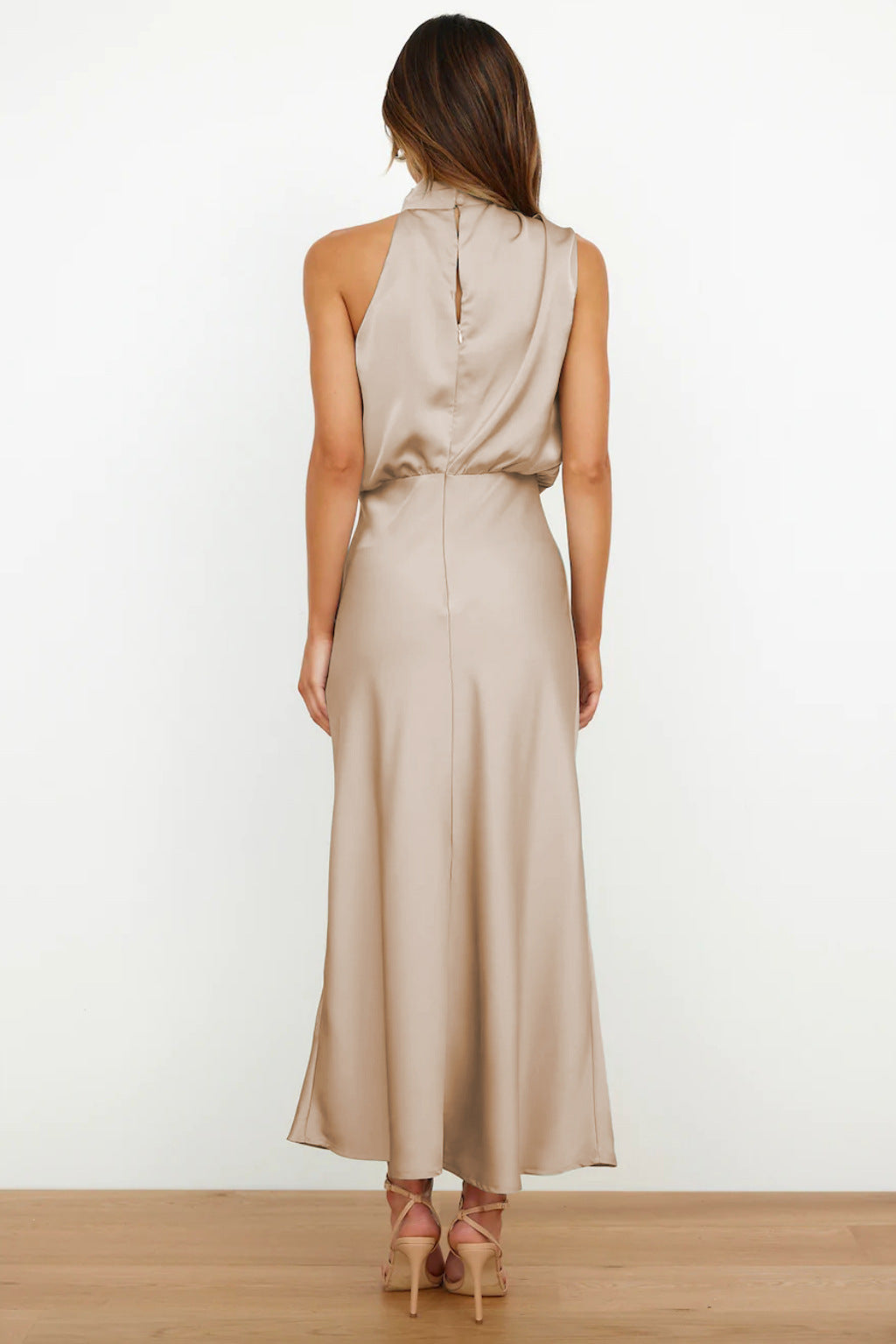 Cette robe en satin beige possède une coupe fluide et élégante. Son dos nu délicat et son tissu doux offrent une allure raffinée, idéale pour des événements formels et des occasions spéciales.