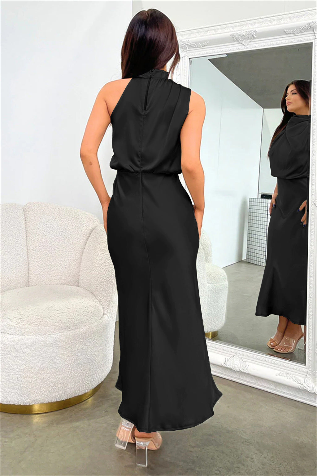 Cette robe noire en satin présente une coupe fluide et élégante. Son dos nu subtil et ses poches ajoutent une touche de praticité et de style, parfaite pour une allure chic et raffinée lors de vos événements.