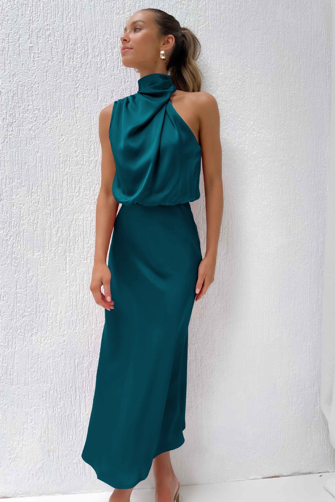Cette robe satinée vert émeraude offre une coupe élégante et fluide. Son décolleté sophistiqué et son dos nu raffiné apportent une touche de classe, parfaite pour des occasions spéciales et des événements formels.