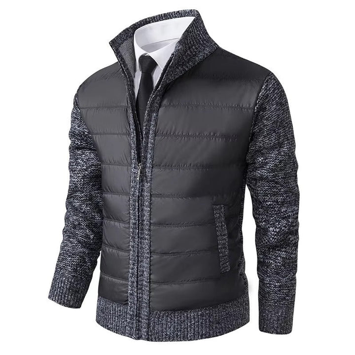 Veste pour homme en maille grise foncé matelassée avec manches en maille grise. Elle est dotée d'une fermeture éclair centrale et de poches latérales, offrant un style moderne et élégant, idéal pour les journées fraîches.
