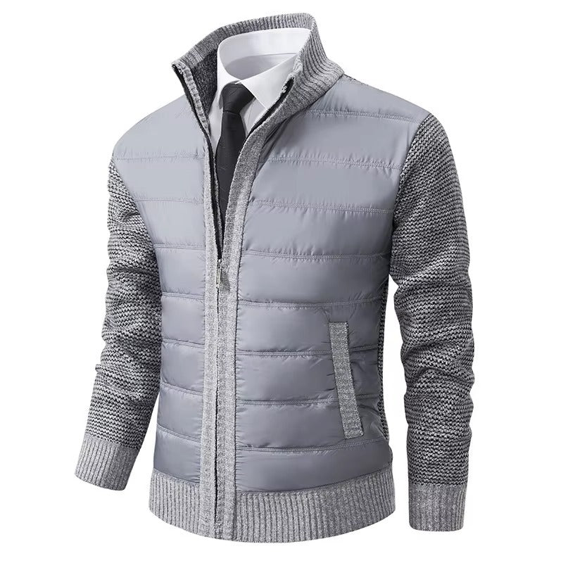 Veste pour homme, avec un corps matelassé gris clair et des manches en tricot gris. Elle dispose d'une fermeture éclair centrale et de poches latérales, alliant confort et style moderne pour un look pratique et élégant.