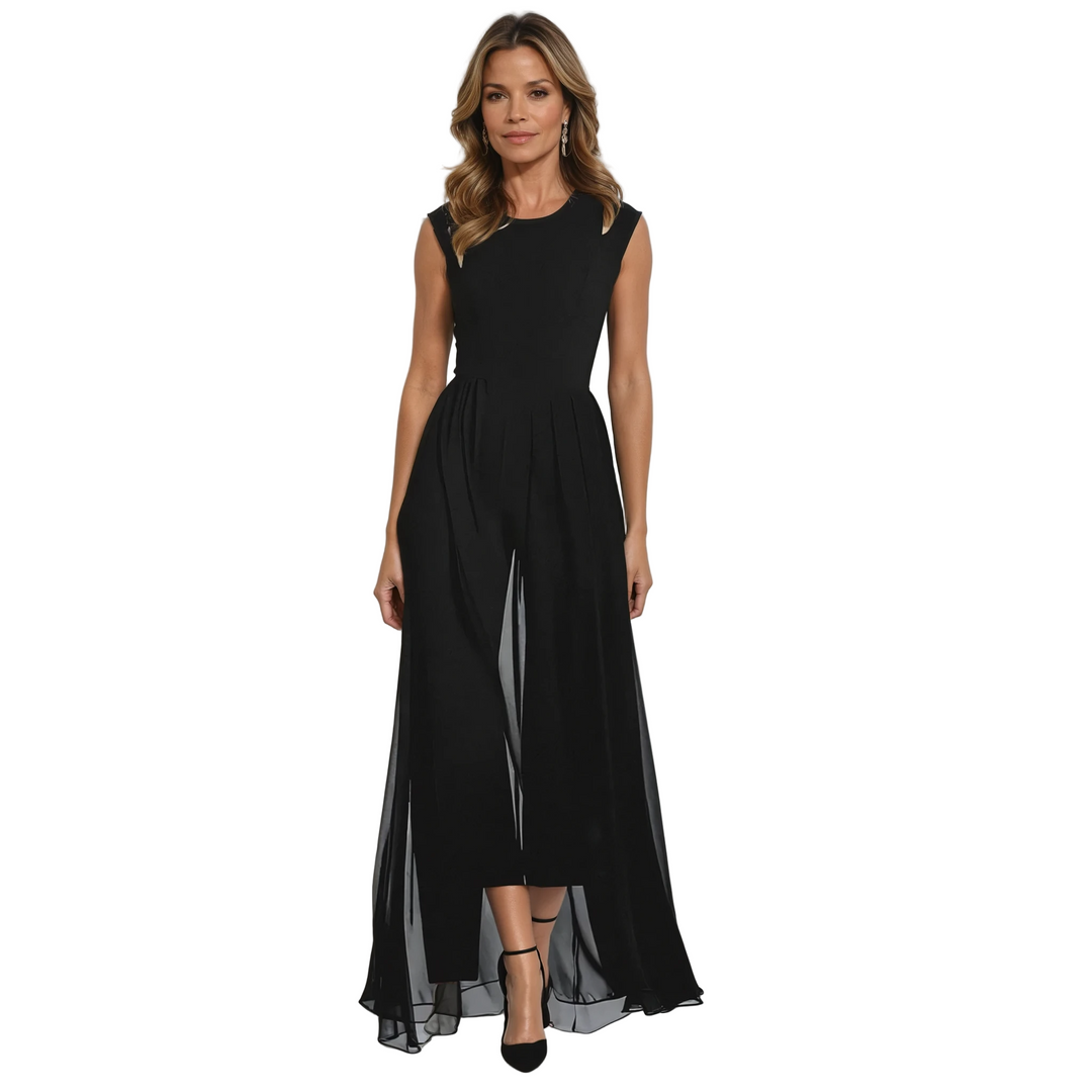 Femme portant une combinaison élégante noire sans manches, dotée d’un haut ajusté et d’un pantalon fluide recouvert d’un tissu léger et transparent. La coupe met en valeur la silhouette tout en offrant une allure raffinée et moderne. La tenue est complétée par des escarpins noirs à bride et des boucles d’oreilles discrètes, idéale pour les soirées, les réceptions ou les occasions estivales habillées.