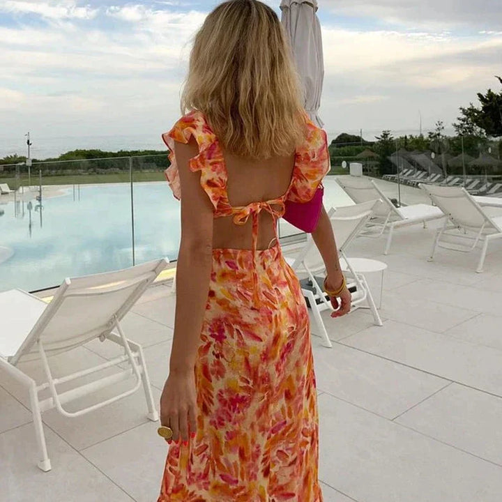 Robe longue à motif floral pour femme, avec un dos nu et un joli noeud à la taille. Cette robe estivale aux tons vibrants de rose et orange est idéale pour un look décontracté et élégant au bord de la piscine ou lors de vos journées ensoleillées.