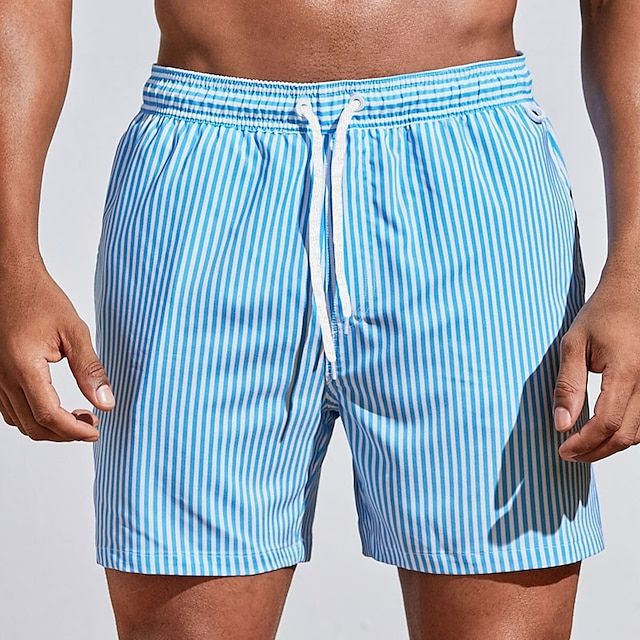 Tendance, short bleu à rayures verticales blanches avec taille élastique et cordon blanc, porté sur fond clair.