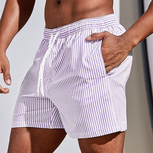 Tendance, short à rayures verticales violet clair et blanc avec taille élastique, cordon blanc et poches, porté sur fond lumineux.
