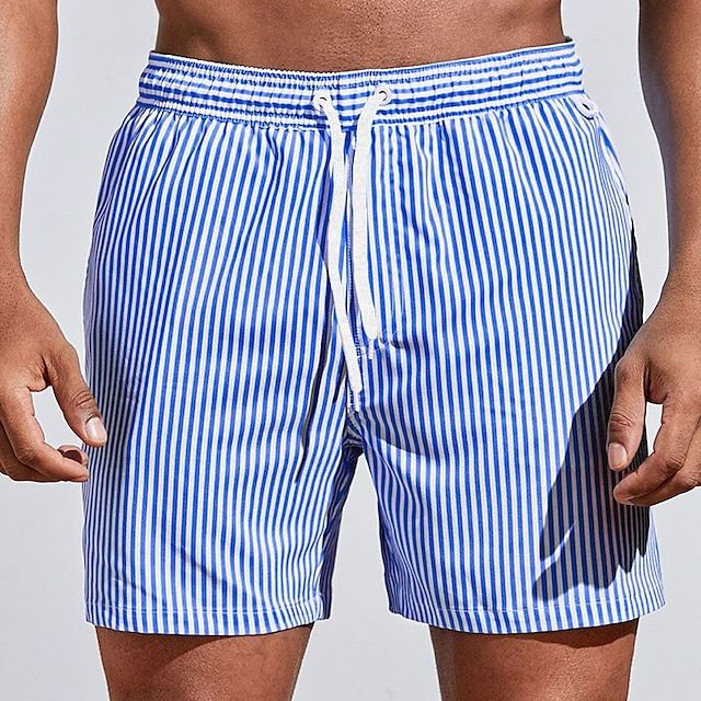Tendance, short bleu roi à rayures verticales blanches avec taille élastique et cordon blanc, porté sur fond clair.