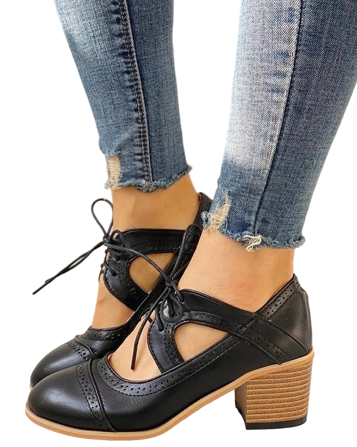 Chaussures noires style Mary Jane rétro avec lacets croisés, détails perforés et talon carré effet bois, portées avec un jean sur sol clair.