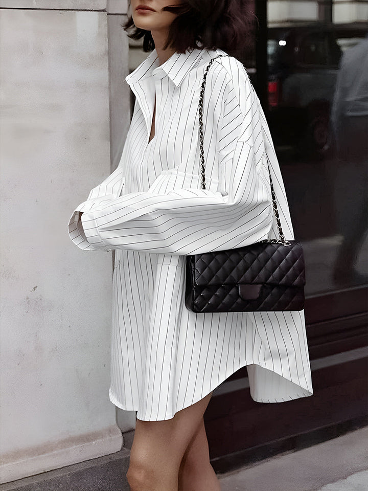 Chemise rayée oversize Noura pour femme, avec un col classique et une coupe ample. Idéale pour un look décontracté et moderne, cette chemise à rayures fines est parfaite pour un style élégant et confortable, accompagnée d'une petite sacoche chic.