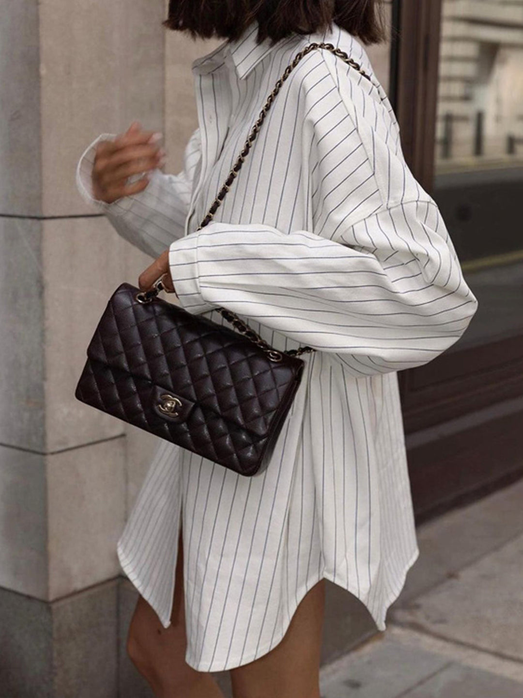Chemise rayée oversize Noura pour femme, à la coupe ample et décontractée, avec un col classique et des manches longues. Portez-la comme une robe ou une chemise pour un look moderne, élégamment associé à un sac chic.