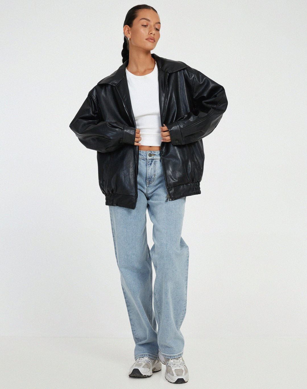 Veste oversize en PU pour femme, modèle Ombeline. Veste en simili-cuir noir à la coupe ample, portée avec un t-shirt blanc et un jean décontracté. Un look moderne et stylé, idéal pour l'hiver.