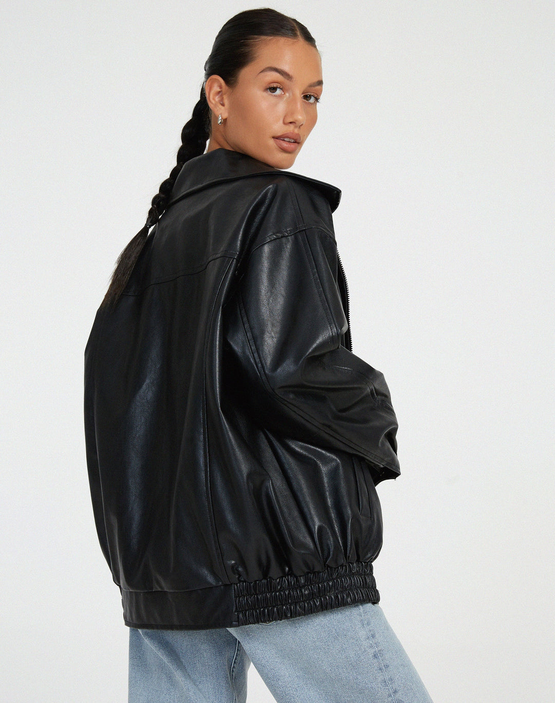 Vue arrière de la veste oversize en PU pour femme, modèle Ombeline. Veste en simili-cuir noir à la coupe ample et taille élastiquée, portée avec un jean décontracté. Un style moderne et confortable, idéal pour l'hiver.