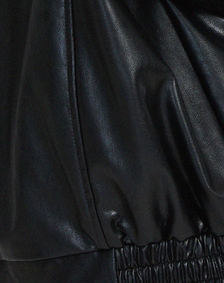 Détail de la veste oversize en PU pour femme, modèle Ombeline. Zoom sur la finition de la taille élastiquée en simili-cuir noir, soulignant le style ample et décontracté de la veste, parfaite pour l'hiver.