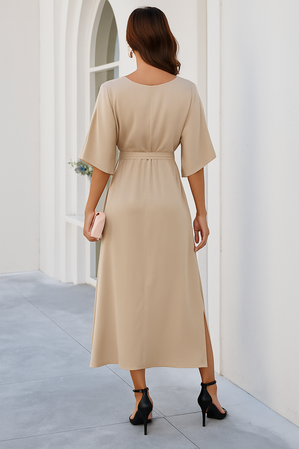 Vue arrière de la robe midi à col en V pour femme, avec une coupe fluide et élégante. Le lien à la taille met en valeur la silhouette, tandis que la fente latérale ajoute une touche moderne. Disponible en beige, cette robe tendance est parfaite pour les journées printanières et les occasions élégantes.