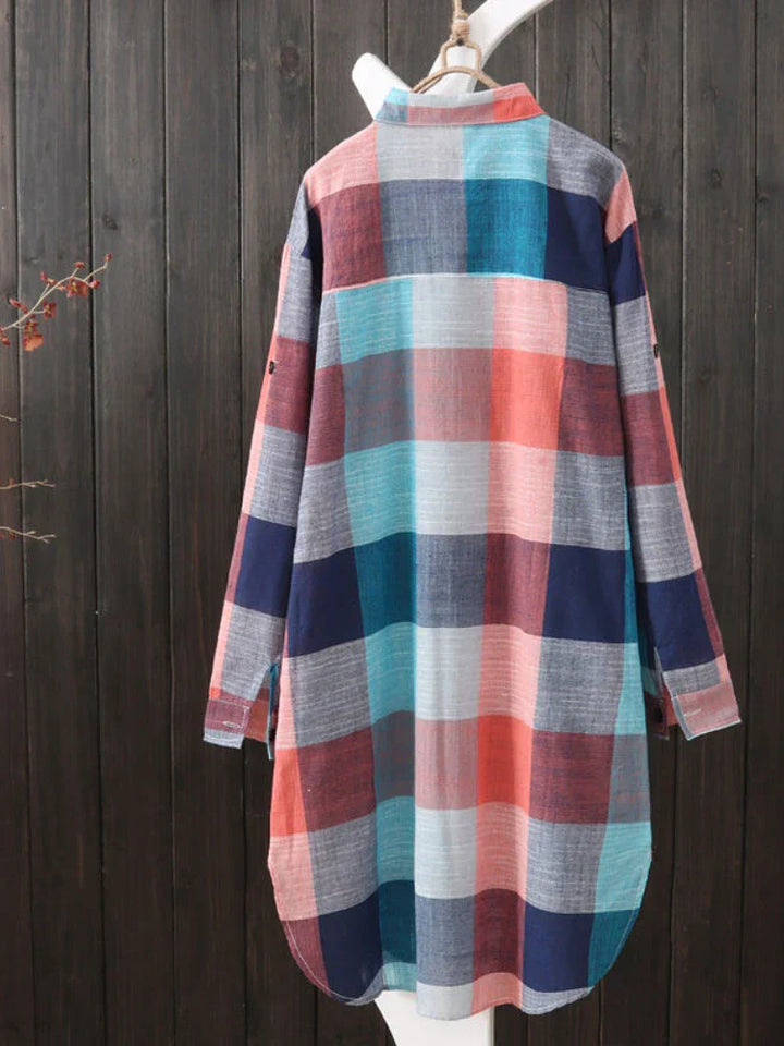 Vue arrière de la chemise boutonnée femme Perrine moderne à carreaux multicolores (bleu, rose, gris et rouge), coupe longue et légère, présentée sur cintre devant un fond en bois.