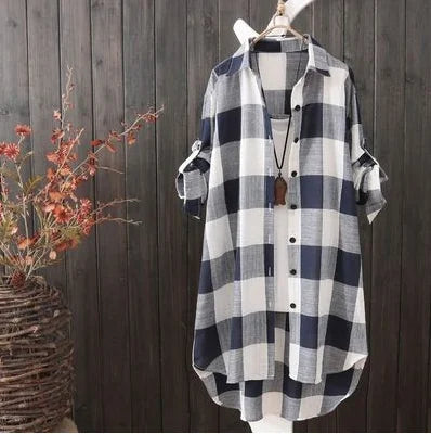 Chemise boutonnée femme Perrine moderne à carreaux noir et blanc, coupe longue et légère avec manches retroussables, présentée sur cintre devant un fond en bois.