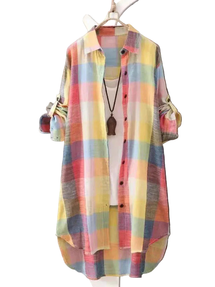 Chemise boutonnée femme Perrine moderne à carreaux multicolores, coupe longue et légère avec manches retroussables, présentée sur cintre devant un fond en bois.