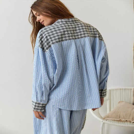 Vue arrière d'un pyjama pour femme à rayures bleues avec des détails à carreaux sur le dos et les épaules. Le haut à manches longues est assorti à un pantalon confortable, offrant un look moderne et élégant, parfait pour une tenue de nuit stylée.