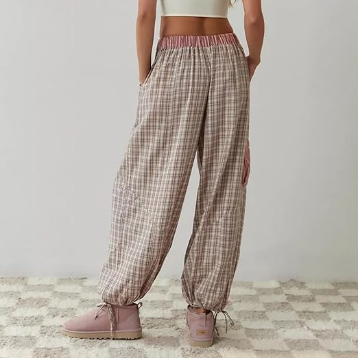 Vue arrière d'un pantalon de pyjama pour femme à carreaux, avec une taille élastiquée et des cordons de serrage aux chevilles pour un ajustement confortable. Le look est complété par des poches pratiques et des baskets roses, offrant une allure décontractée et moderne.