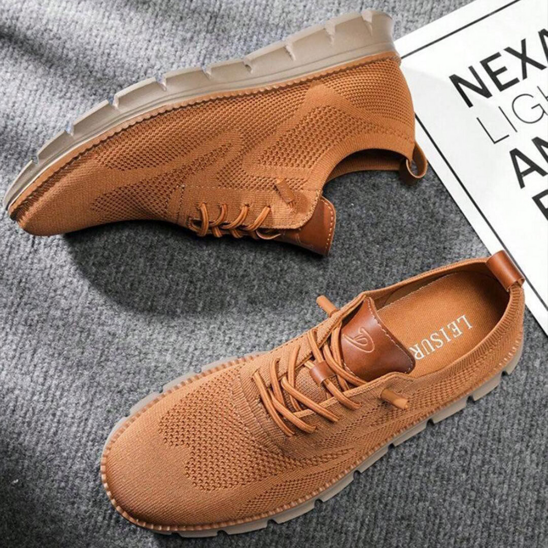 Paire de chaussures urbaines camel en maille respirante avec lacets et détails en simili cuir, semelle épaisse crantée, posée sur un tapis gris.