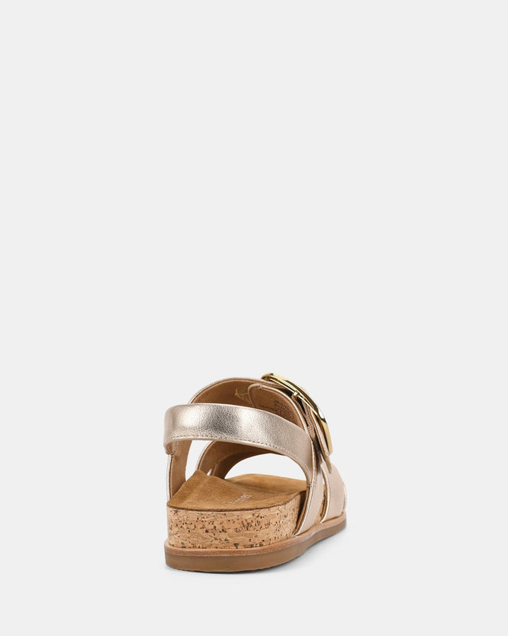 Vue arrière des sandales avec une boucle dorée et une semelle en liège, offrant confort et style pour la saison estivale.