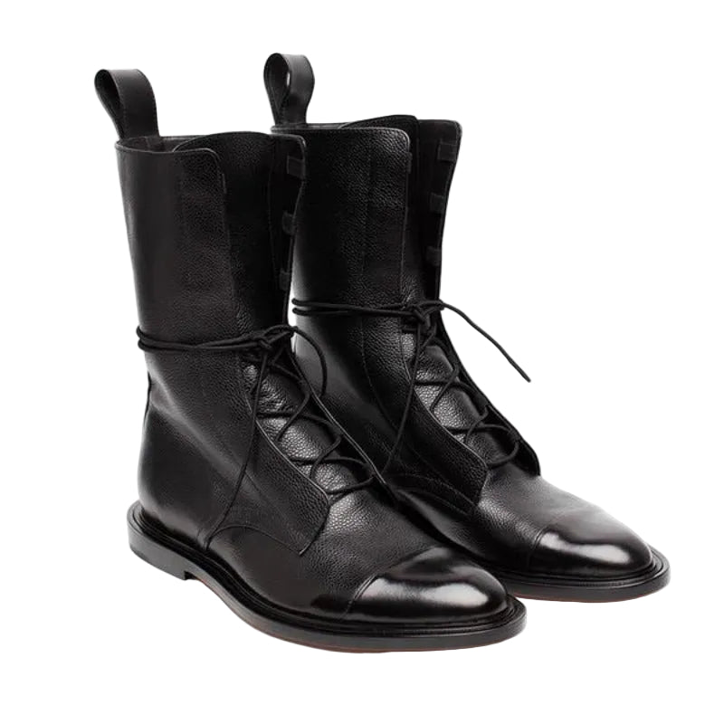 Bottines cheville pour femme en cuir noir à texture grainée, avec tige mi-mollet, laçage croisé sur le devant, languette arrière et semelle plate élégante, présentées sur fond blanc.