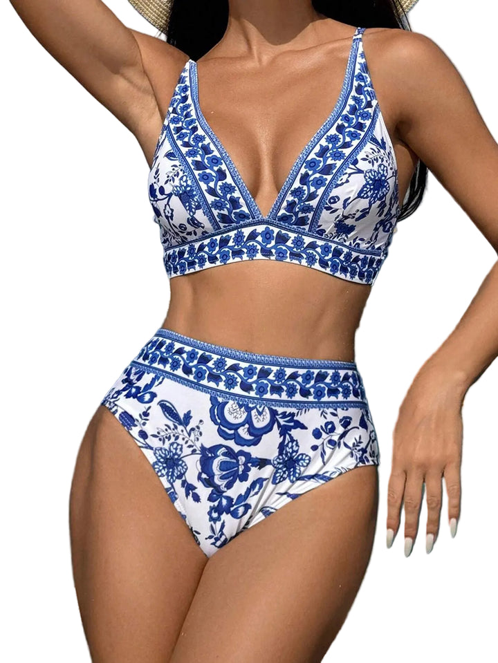 Bikini femme Rose à motif floral bleu et blanc, avec haut à col en V et fines bretelles, accompagné d’une culotte taille haute assortie, porté en bord de mer pour un look estival élégant et tendance.