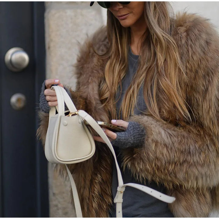 Mode automnale féminine : combinaison d’une veste pelucheuse et d’un jean boyfriend devant un fond urbain.