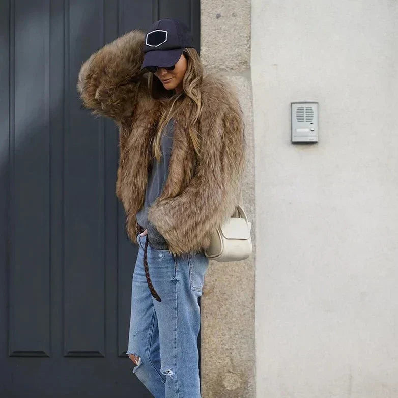 Look automnal chic avec veste duveteuse marron, t-shirt gris et lunettes de soleil rondes.