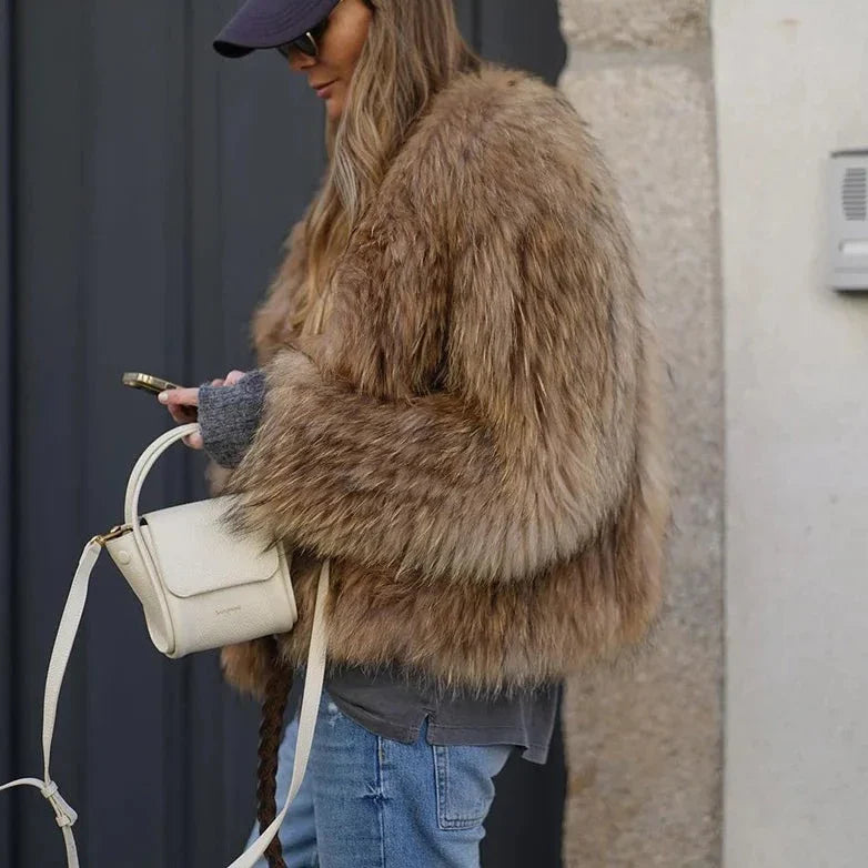 Femme élégante au look casual chic avec veste marron, top gris et sac beige.