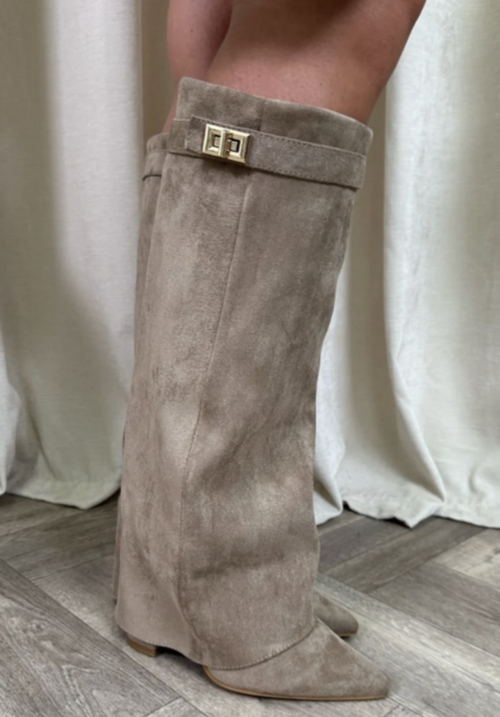 Bottes taupe effet daim à bout pointu, coupe mi-mollet avec revers et boucle dorée, vue de profil sur sol en bois.