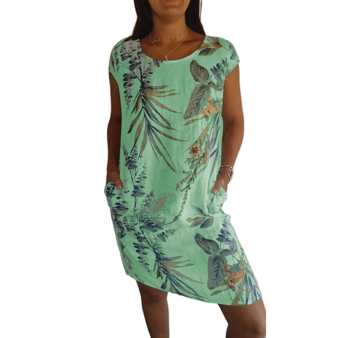Cette robe d'été légère en lin, avec un imprimé tropical vibrant, offre une coupe décontractée et confortable. Elle présente des poches latérales pratiques et un design frais et coloré, parfait pour les journées chaudes. Idéale pour un look estival élégant et pratique.