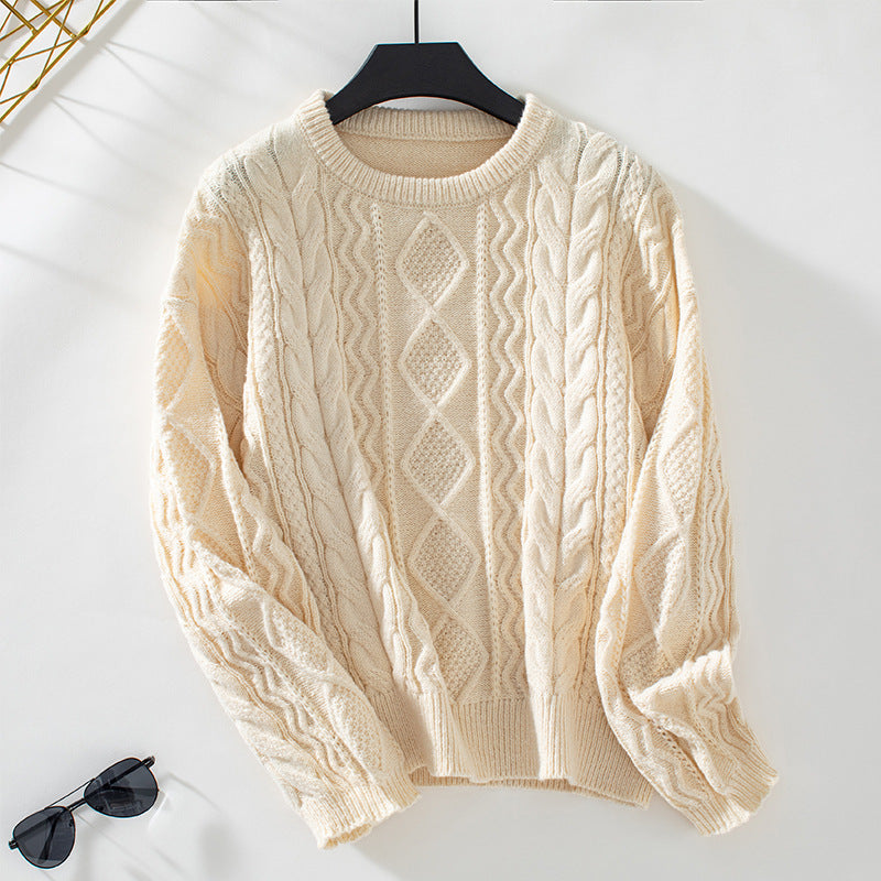 Un pull blanc en maille torsadée orné d'un motif losange géométrique sur le devant. Sa coupe ample et ses manches longues en font le vêtement idéal pour un look décontracté et moderne. La maille offre une texture douce et épaisse, parfaite pour les temps frais. Le pull est présenté sur un cintre noir devant un fond blanc éclatant, accompagné d'une paire de lunettes de soleil pour une allure élégante et minimaliste.